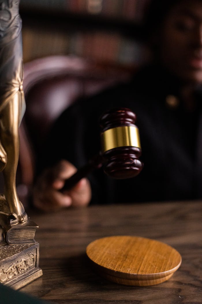 heros-img Close-up of a judge holding a gavel, symbolizing justice and law in a courtroom setting.